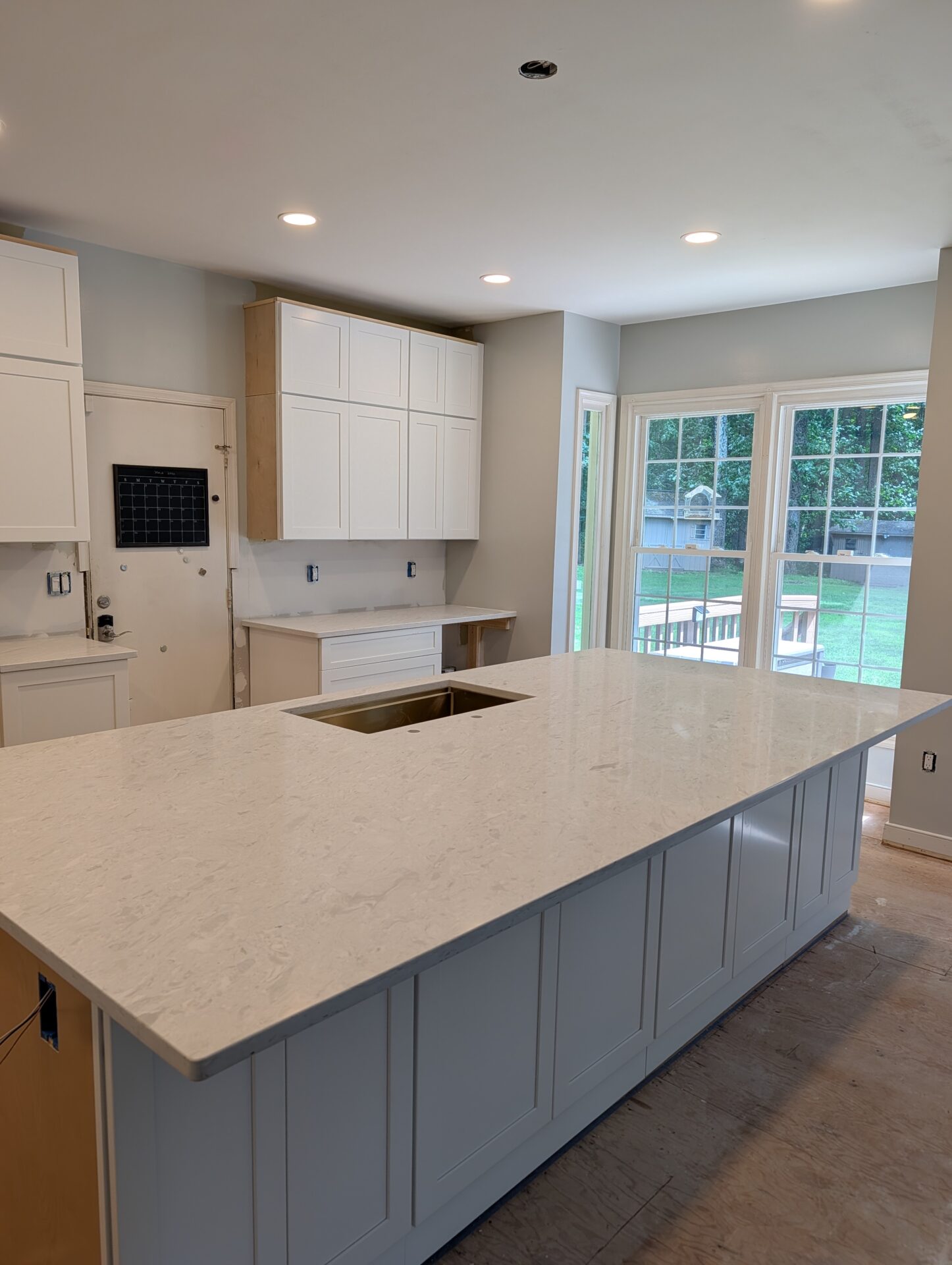 White shaker cabinets and quartz island with walls repainted during kitchen renovation