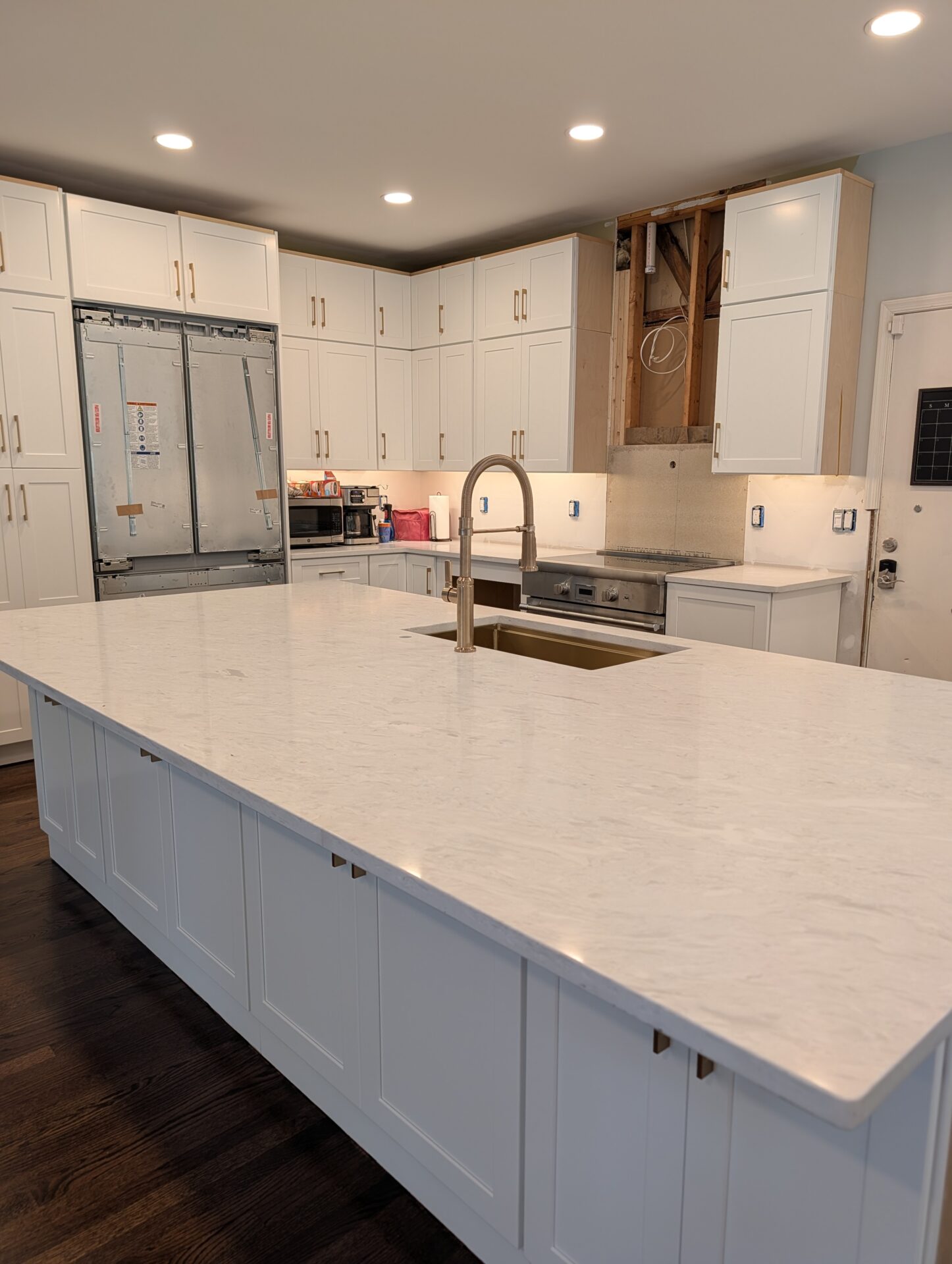 Panel-ready refrigerator and pro range installed with new hardwood flooring during kitchen remodel