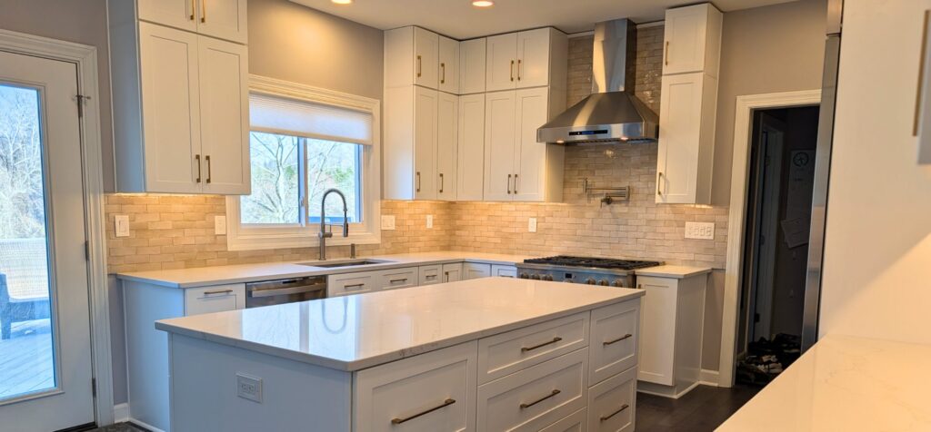 tco hero kitchen 1 TCO Handyman Renovation Services Central Maryland Remodeled white kitchen with quartz island, stainless range hood and tile backsplash