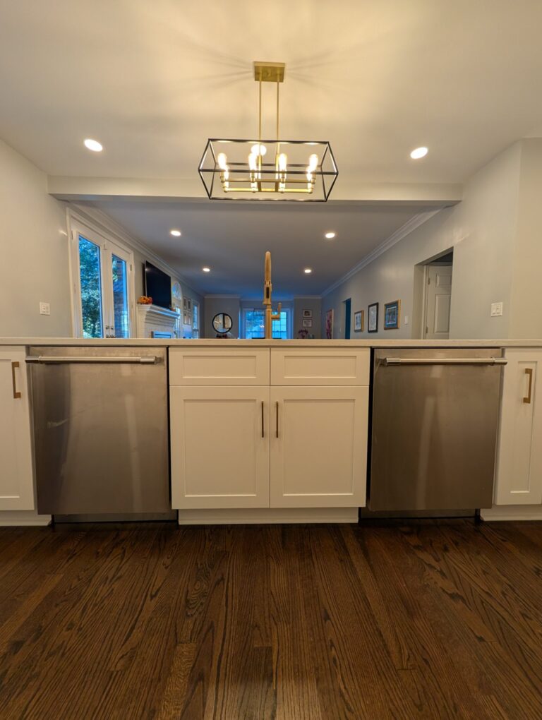 New island sink cabinet between two dishwashers, looking through the new opening into the living room