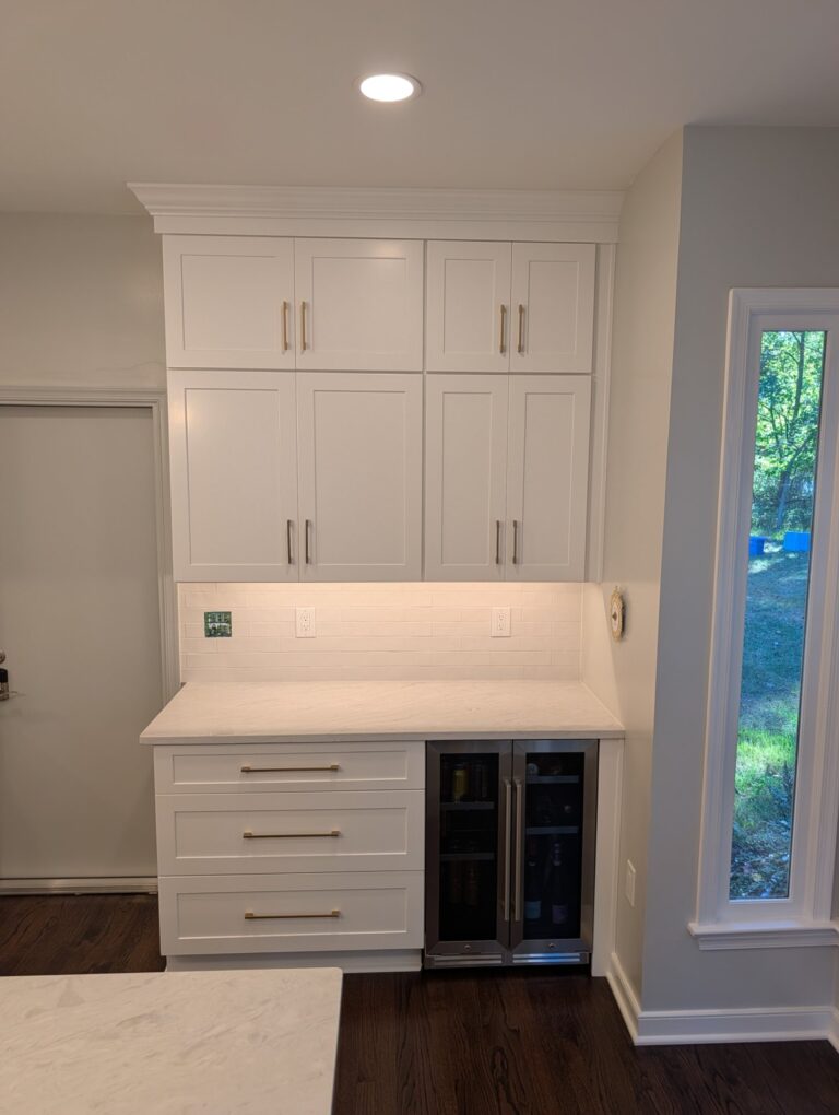 Beverage station with shaker wall cabinets to the crown molding, a drawer base and an under-counter beverage refrigerator